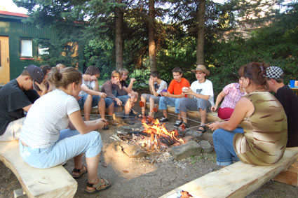 Účastníci letního tábora při posezení u táboráku.